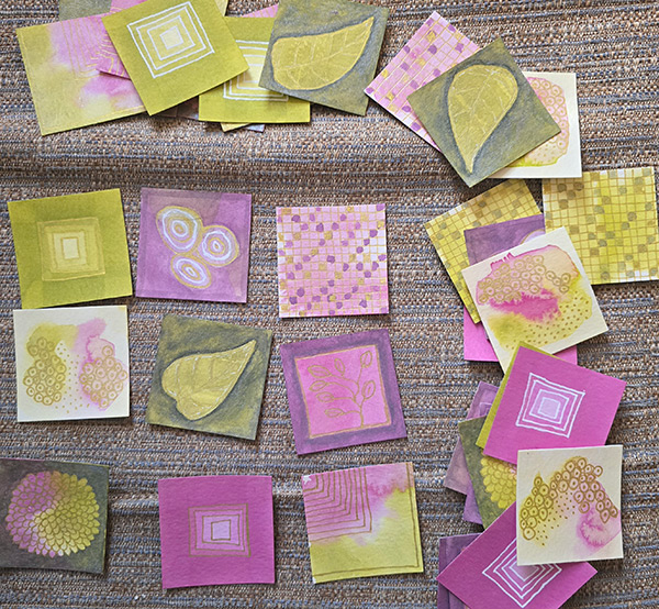 small pieces of watercolor paper with pink and chartreuse paint underneath gold drawings